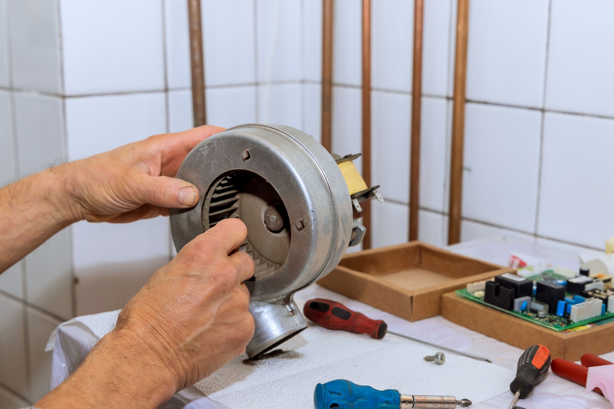 Technician performs maintenance, repairs of a gas boiler air turbine, cleaning from dust