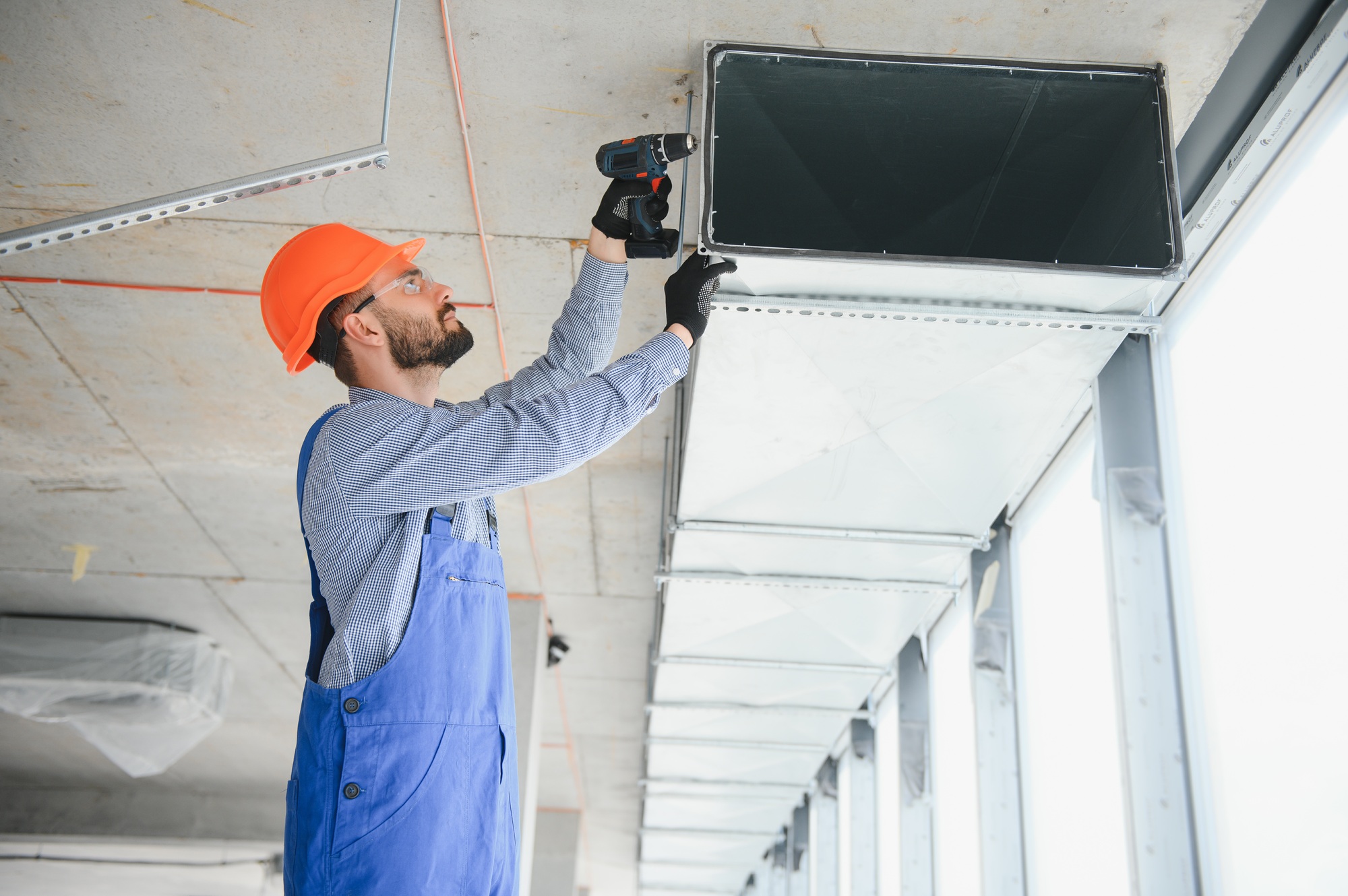 Warehouse Heating and Cooling System Installation by Professional Caucasian Technician.